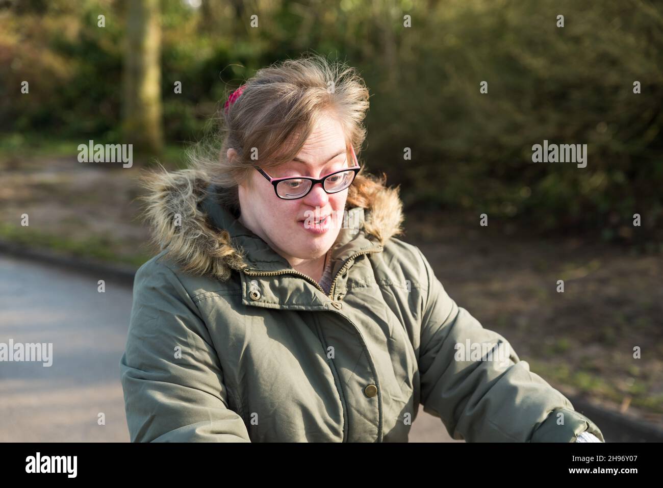 Tienen, Flandre / Belgique - 07 20 2018: Portrait d'une jeune femme blanche avec le syndrome de Down conduisant un tricycle à travers les champs Banque D'Images