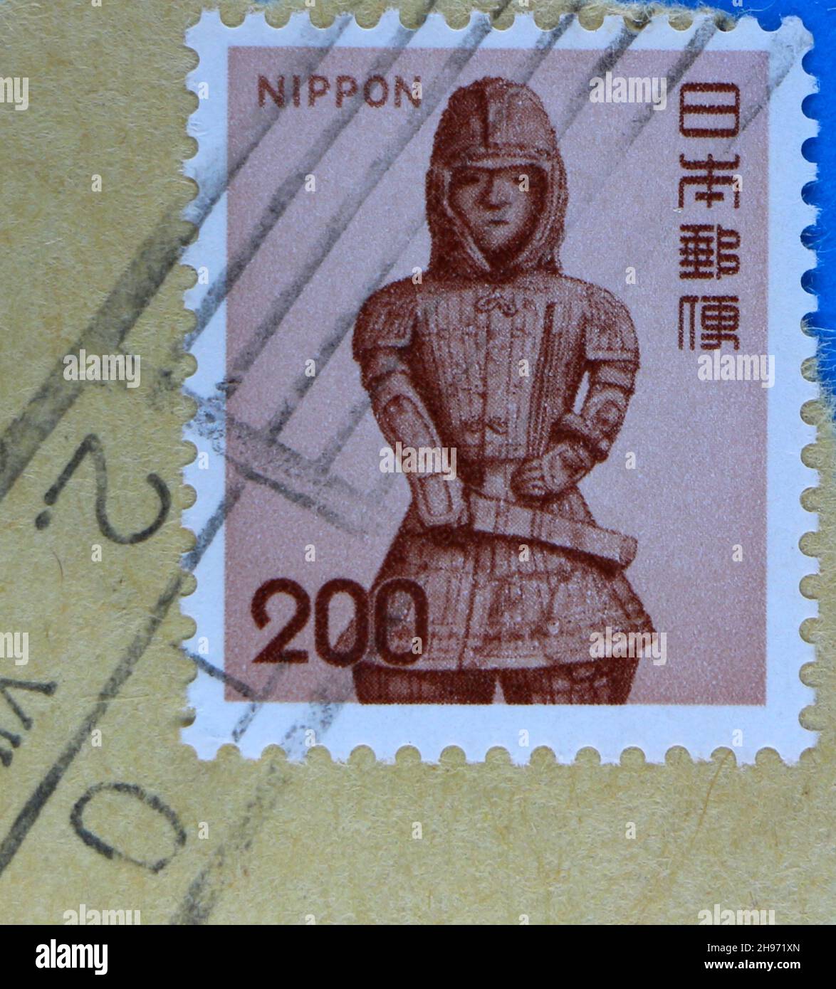 Photo d'un ancien timbre-poste japonais utilisé avec une illustration d'une figure monochrome costumée Banque D'Images