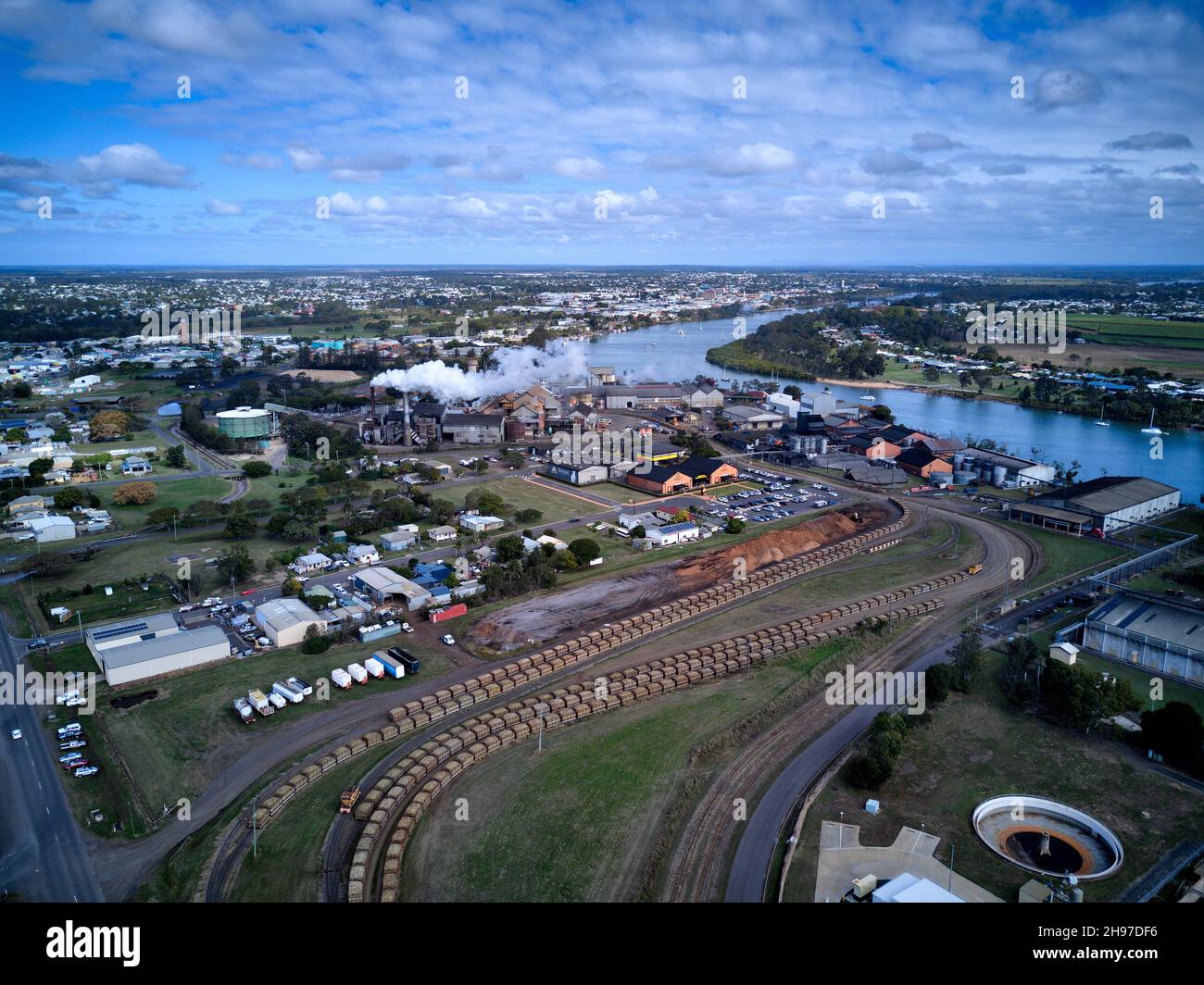 Antenne des trains de canne à sucre se ramenant dans le moulin à sucre de Millaquin et la distillerie de Bundaberg Rum Queensland Australie Banque D'Images