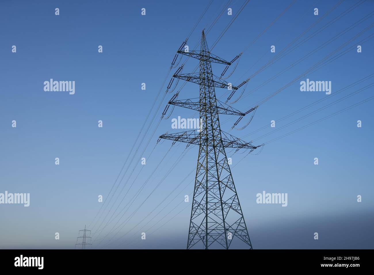 Deux pylônes d'électricité (Strommasten) également pylônes de ligne aérienne.Gris matin d'hiver avant le coucher du soleil. Vue sur le haut. Banque D'Images