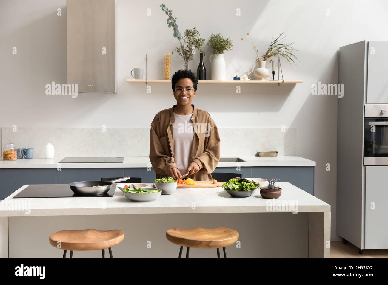 Portrait d'une jeune femme afro-américaine souriante qui cuisine dans la cuisine. Banque D'Images
