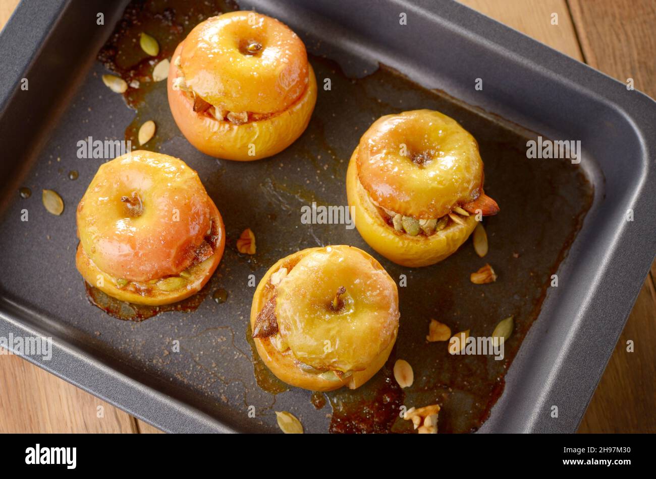 Des Pommes au four farcies aux noix et amandes, graines de citrouille en gros plan de cuisson Banque D'Images