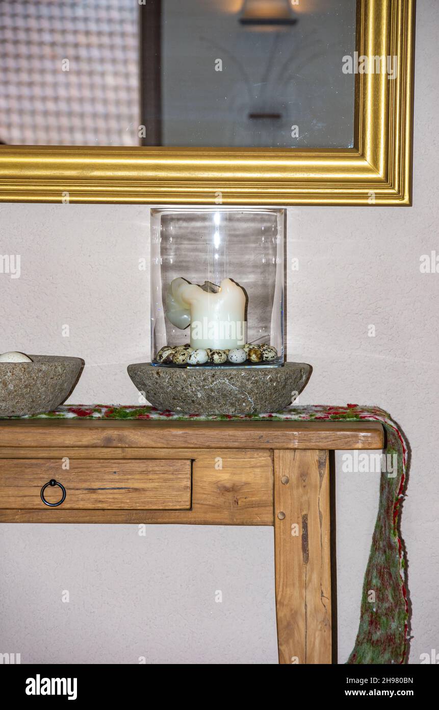 Détails d'un intérieur rustique avec petite table, miroir et différentes décorations. Banque D'Images