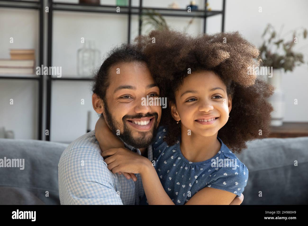 Deux générations rêveuses de famille afro-américaine se câliner à la maison. Banque D'Images