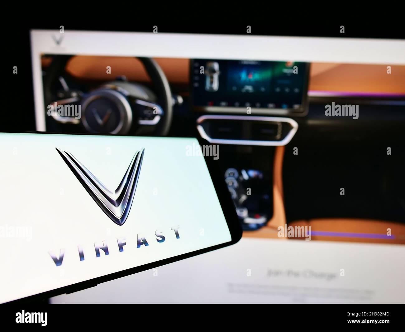 Téléphone mobile avec logo du fabricant de voitures vietnamien VinFast sur l'écran en face du site Web d'affaires.Mise au point au centre-gauche de l'écran du téléphone. Banque D'Images