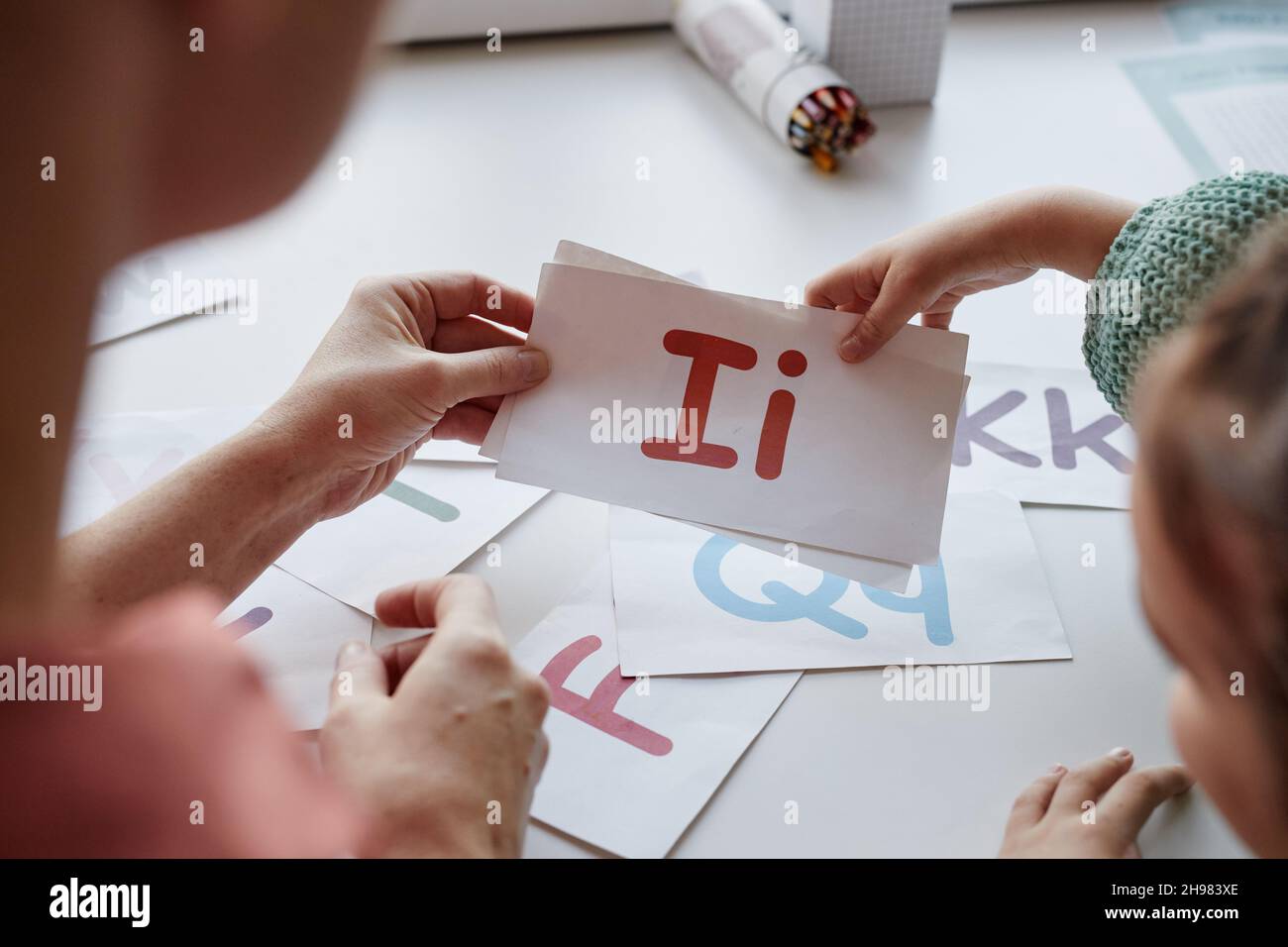 Gros plan de l'apprentissage des enfants lettres anglaises avec des cartes avec l'enseignant à la table Banque D'Images
