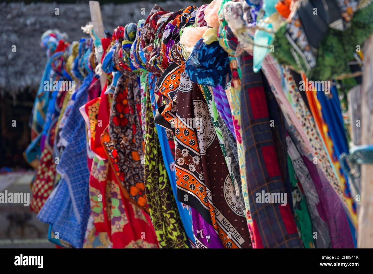 Vêtements en tissu traditionnel coloré en vente sur la plage, Diani, Kenya Banque D'Images
