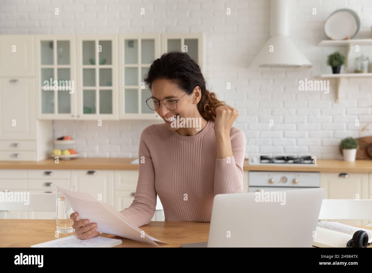Femme en lunettes lisant de bonnes nouvelles dans la lettre, célébrant le succès Banque D'Images
