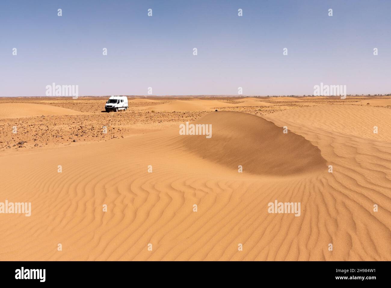 Dans le désert du Sahara au Maroc.Un minibus 4x4 au milieu des dunes près de erg Chégaga Banque D'Images