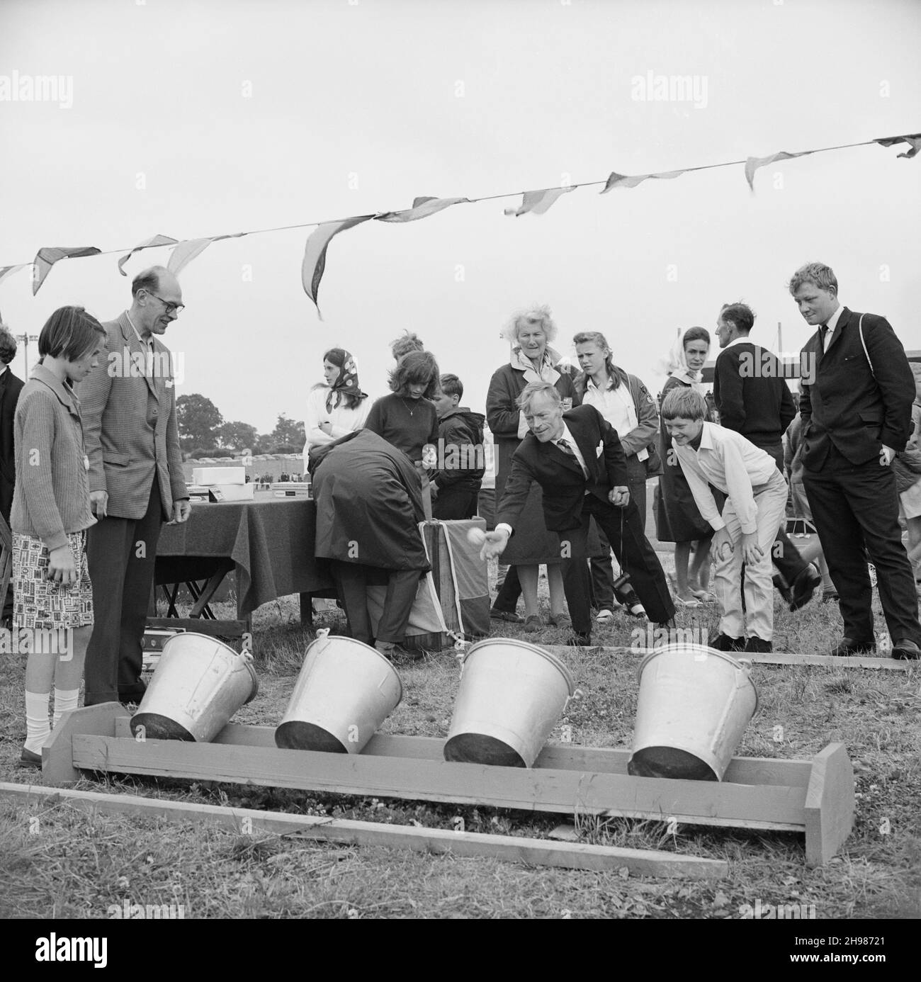 Stade Copthall, Hendon, Barnett, Londres, 25/06/1966.Un homme qui lance une balle dans un match de balle dans le seau lors d'un salon organisé lors de la Journée annuelle des sports de Laing au stade de Copthall en 1966, la Journée annuelle des sports des employés de Laing a eu lieu le 25 juin au stade de Copthall à Hendon.C'était la première fois que l'événement s'y tenait, ayant eu lieu auparavant le terrain de sport de Laing à Elstree.Parmi les différents événements, on compte l'athlétisme et une compétition de football, et les concurrents ont voyagé depuis les bureaux et sites régionaux de la société, notamment en Écosse et en Carlisle.Il y avait aussi une foire, Banque D'Images