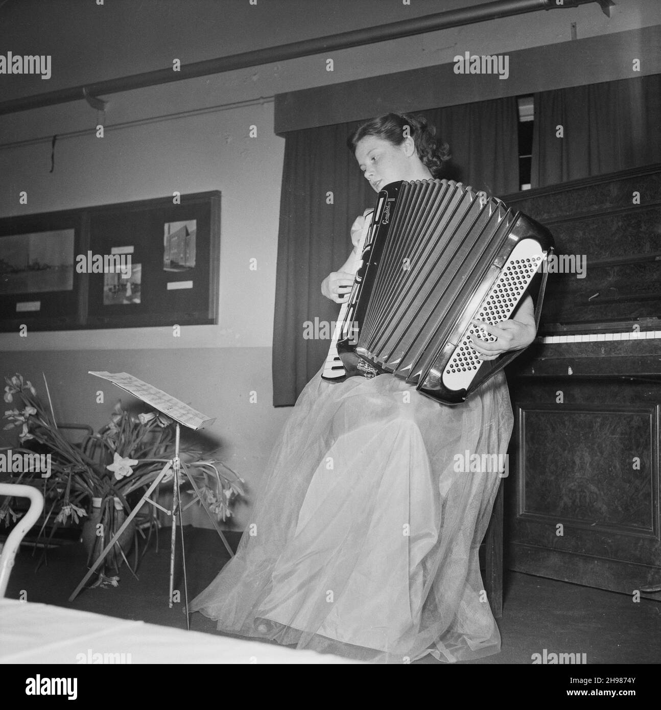 John Laing and son Limited, page Street, Mill Hill, Barnett, Londres,27/03/1953.Vous manquez Un Hatch jouant un accordéon au dîner annuel du Club des sports.Le dîner annuel du club sportif a eu lieu dans la cantine au bureau de Laing's Mill Hill.Après le dîner, l'animation comprenait un récital d'accordéon pour piano et se termine par un chant. Banque D'Images