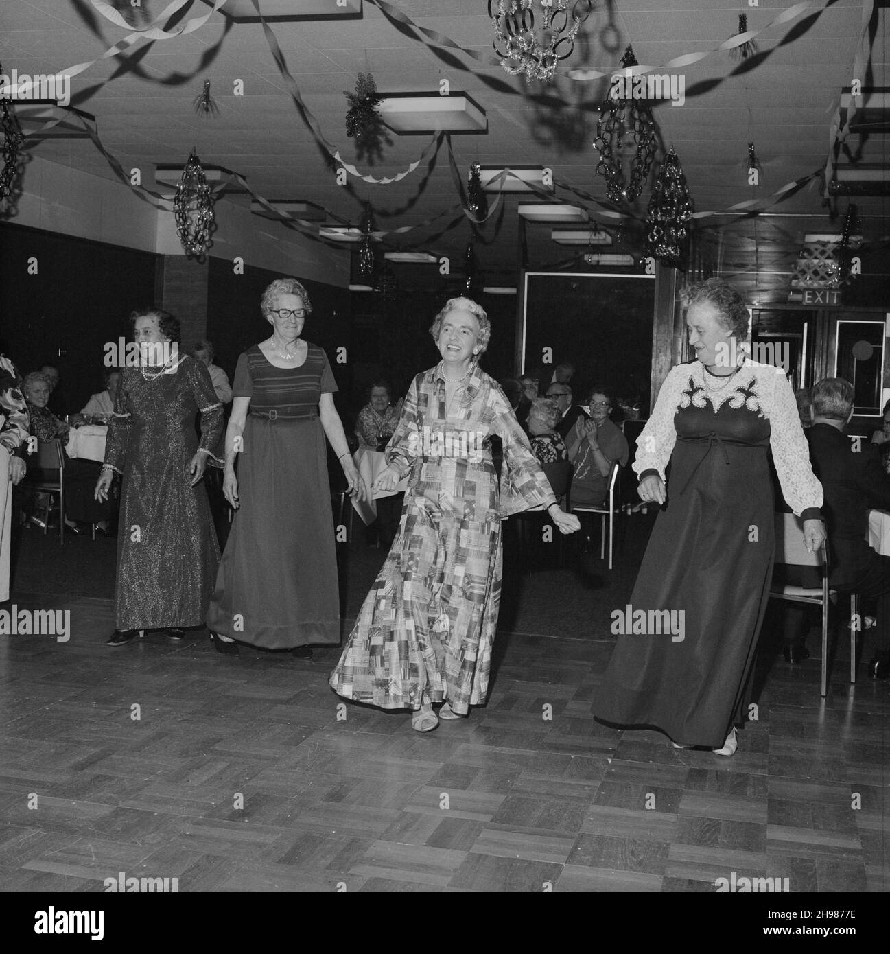 John Laing and son Limited, page Street, Mill Hill, Barnett, Londres,14/12/1978.Quatre femmes dans les robes de soirée sur la piste de danse au dîner de Noël des seniors Laing et dansent à Mill Hill.Le dîner et la danse ont eu lieu dans le restaurant du bureau de Laing's Mill Hill.Il y avait un dîner dinde de trois plats, danse et tombola tout au long de la soirée. Banque D'Images