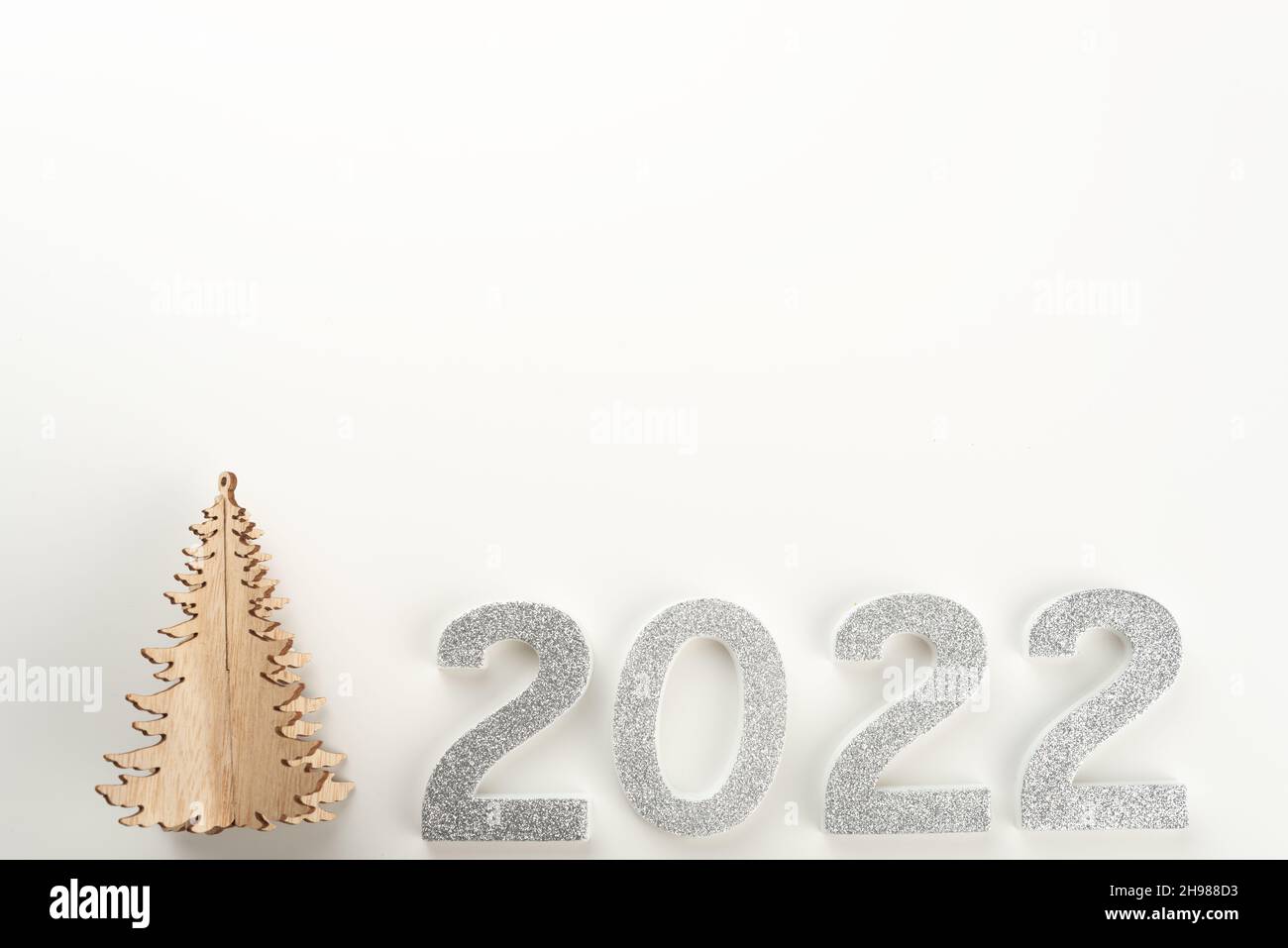 Petit arbre de Noël en bois avec 2022 chiffres sur fond clair.Copier l'espace. Banque D'Images