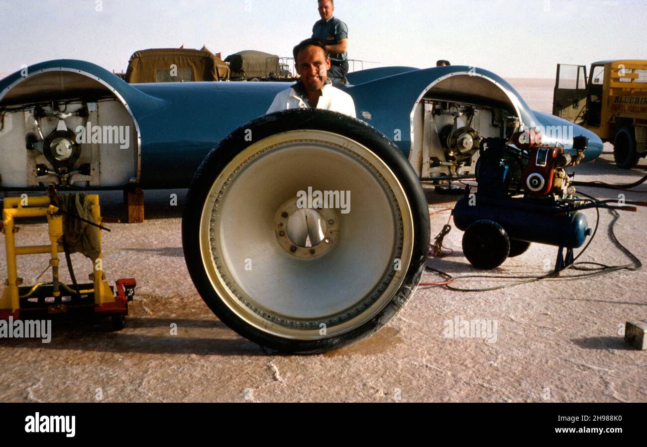 Allan Dougherty, membre de l'équipe de soutien pour Bluebird CN7 World Land Speed Record tentative, tenue sur les roues de la voiture, Lake Eyre, Australie, 1964. Banque D'Images