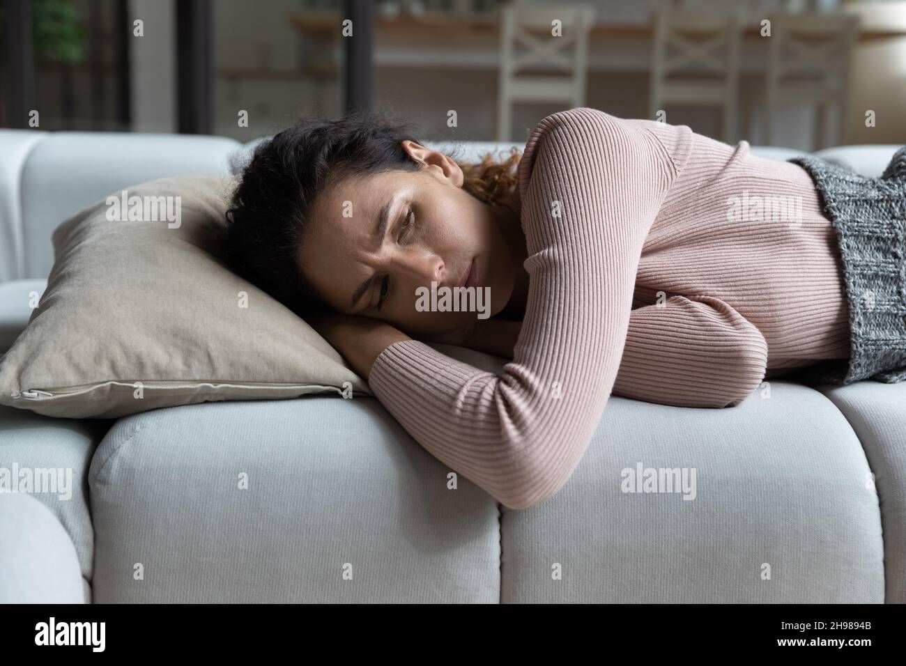 Gros plan une femme malheureuse couchée sur un canapé à la maison seule Banque D'Images