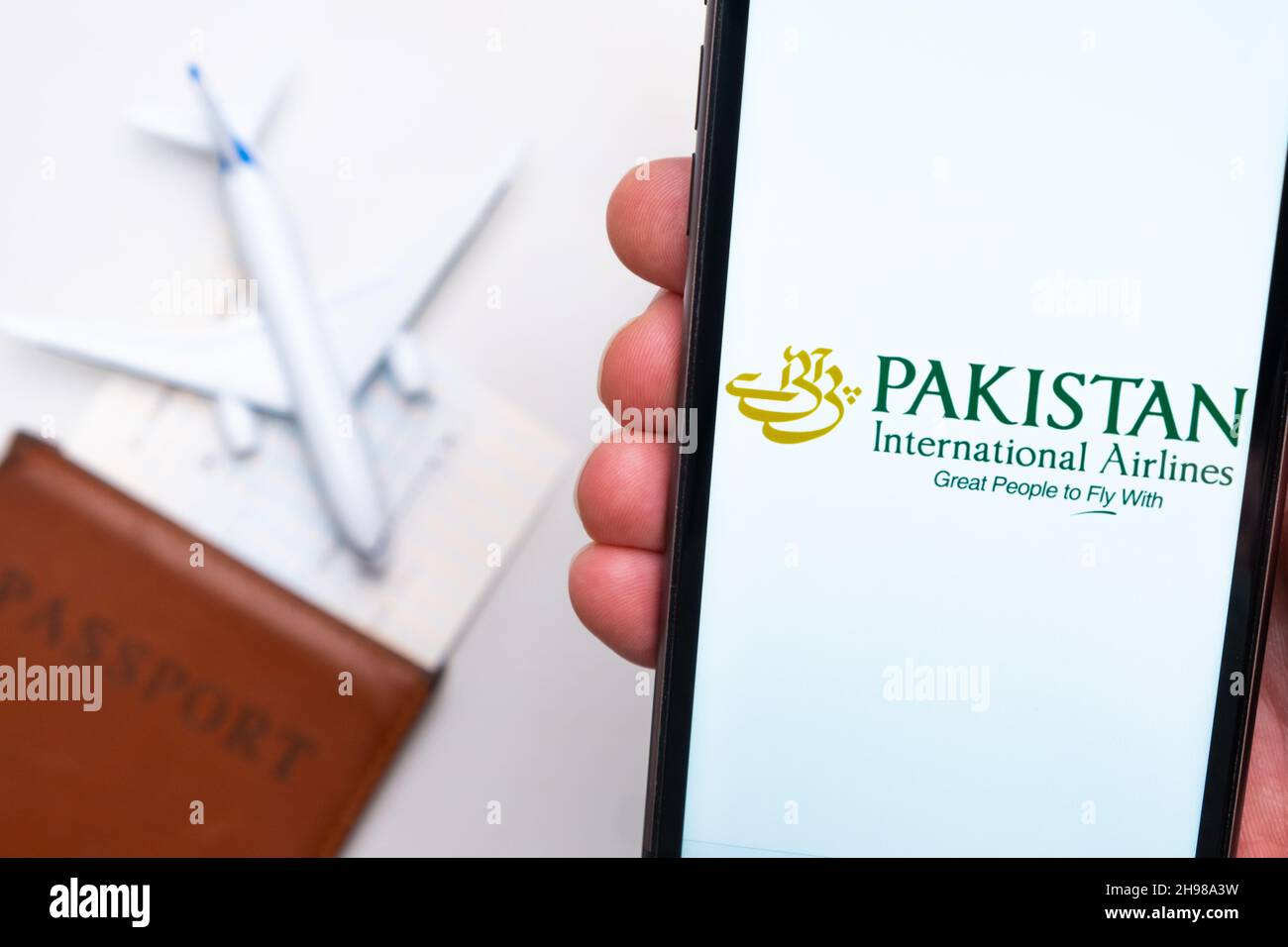 Logo Pakistan International Airlines sur l'écran du téléphone mobile avec un avion, un passeport et une carte d'embarquement en arrière-plan.Le concept de l'application mobile des compagnies aériennes.Novembre 2021, San Francisco, États-Unis Banque D'Images