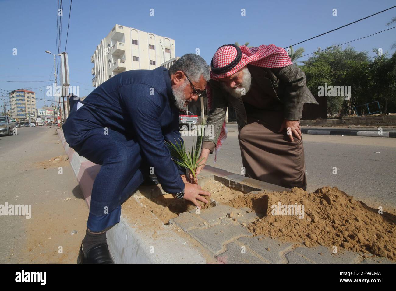 Rafah.5 décembre 2021.Des volontaires palestiniens participent à une campagne de plantation d'arbres à l'occasion de la Journée internationale des volontaires dans la ville de Rafah, dans le sud de la bande de Gaza, le 5 décembre 2021.Credit: Khaled Omar/Xinhua/Alamy Live News Banque D'Images