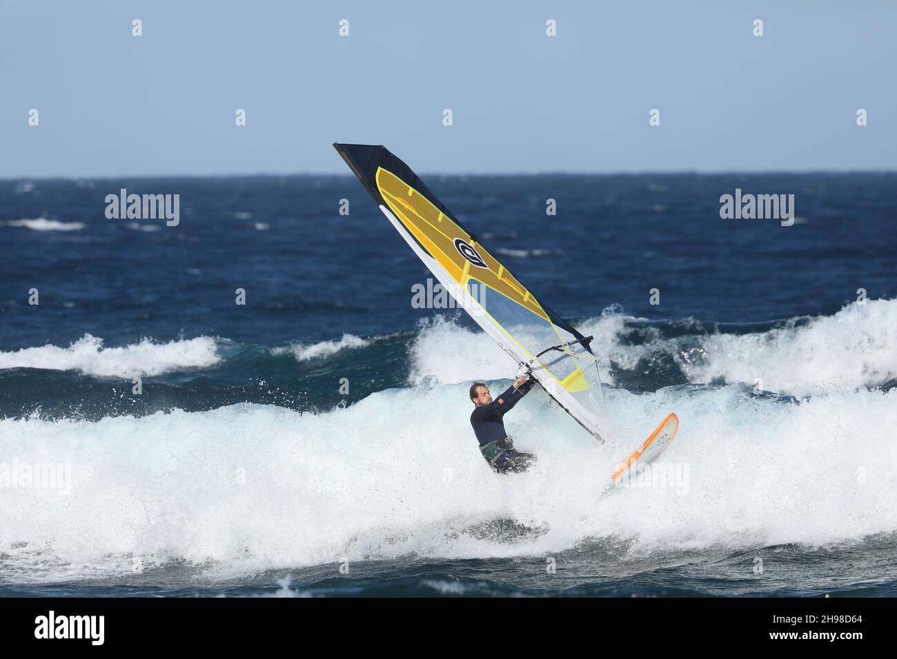 les résidents se précipitent sur les plages pour participer à leur passe-temps de planche à voile, ils connaissent les meilleurs vents et s'amusent fantastique dans le surf. Banque D'Images