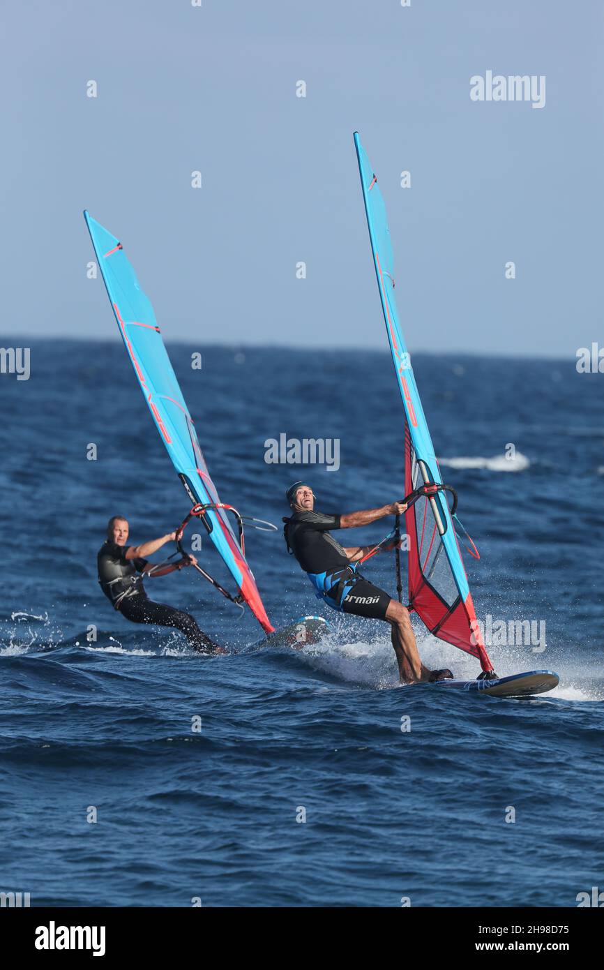 Après le travail de nombreux résidents sur Lanzarote course à la plage pour apprécier le style de vie et le frisson de leur passe-temps - la planche à voile. Banque D'Images