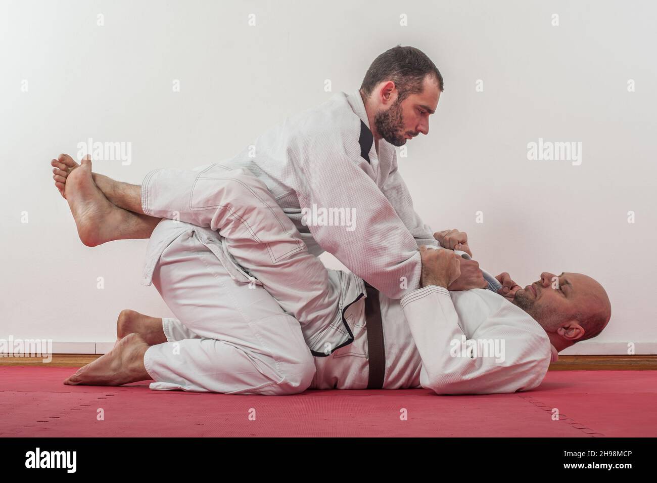 Démonstration brésilienne de formation au jiu-jitsu dans un kimono.BJJ  traditionnel en position fermée de garde Photo Stock - Alamy