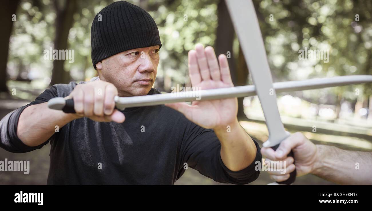 L'instructeur Lameco Astig Combatifs démontre les techniques de combat et les méthodes d'entraînement d'une seule épée et d'une arme à long couteau.Arts martiaux philippins EC Banque D'Images