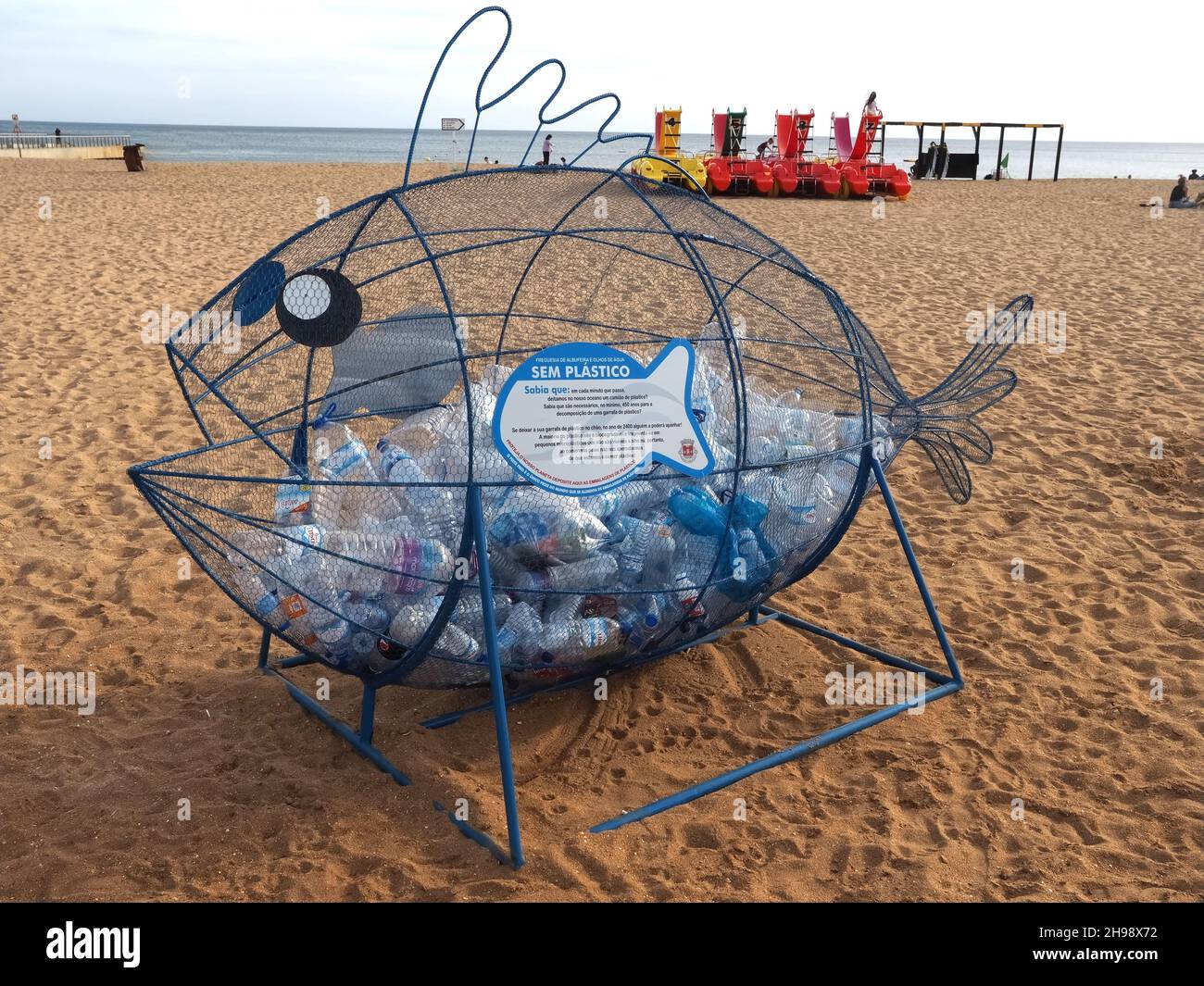 Collection de bouteilles en plastique dans une sculpture de poisson à Albufeira Banque D'Images