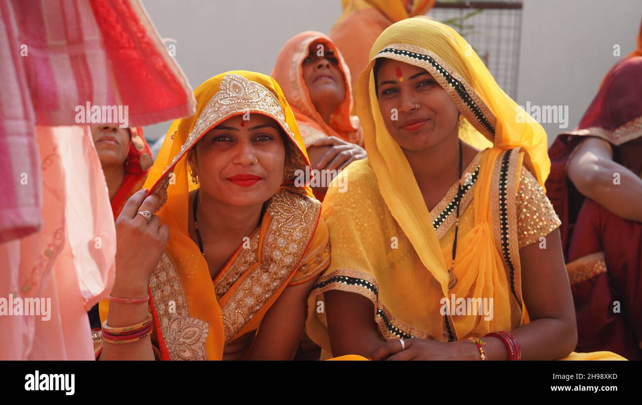 21 novembre 2021 Reengus, Rajasthan, Inde.Deux femmes indiennes en saree jaune regardant l'appareil photo dans une fonction de mariage. Banque D'Images
