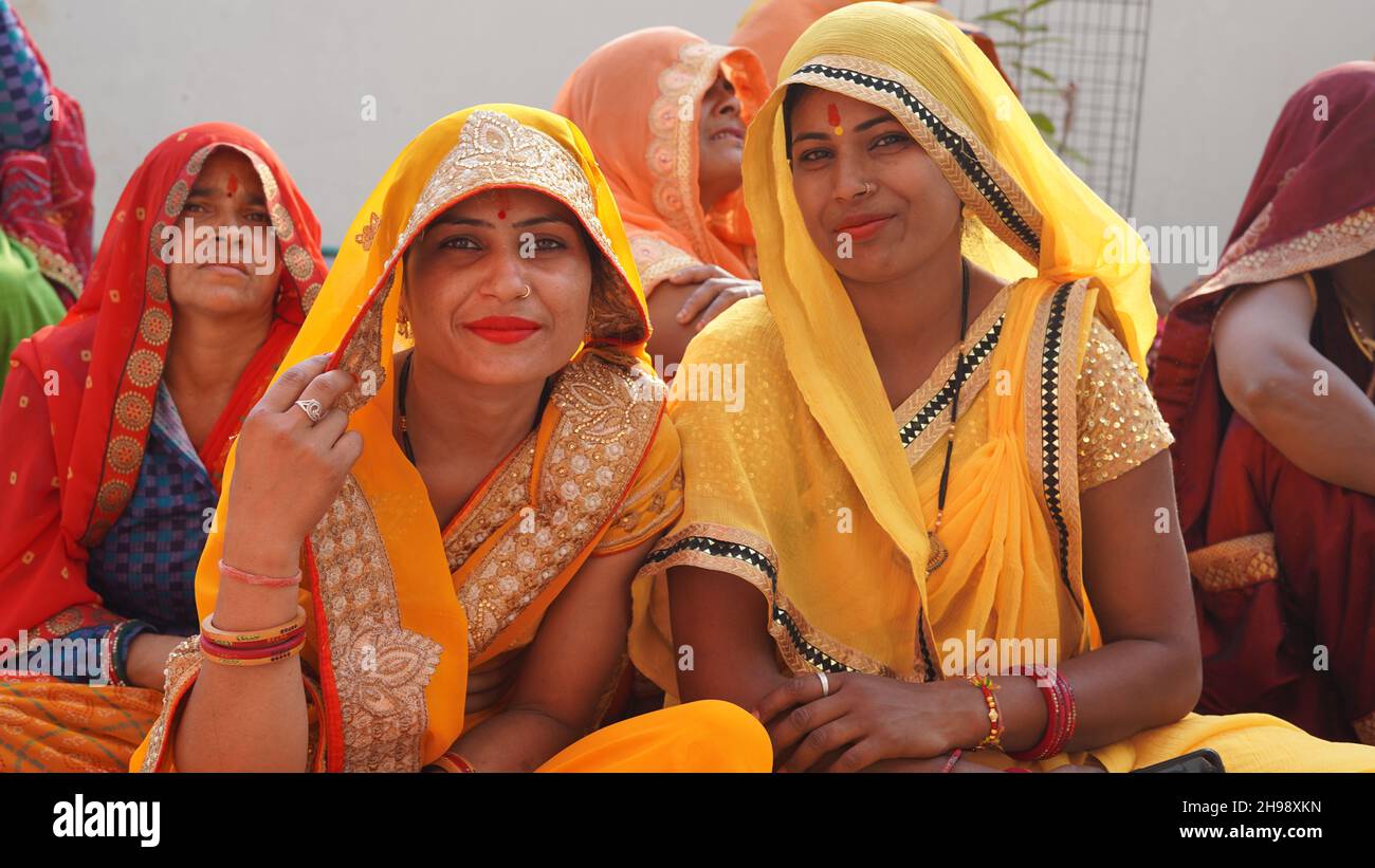 21 novembre 2021 Reengus, Rajasthan, Inde.Des femmes indiennes heureuses en saree jaune regardant l'appareil photo dans un programme de mariage. Banque D'Images