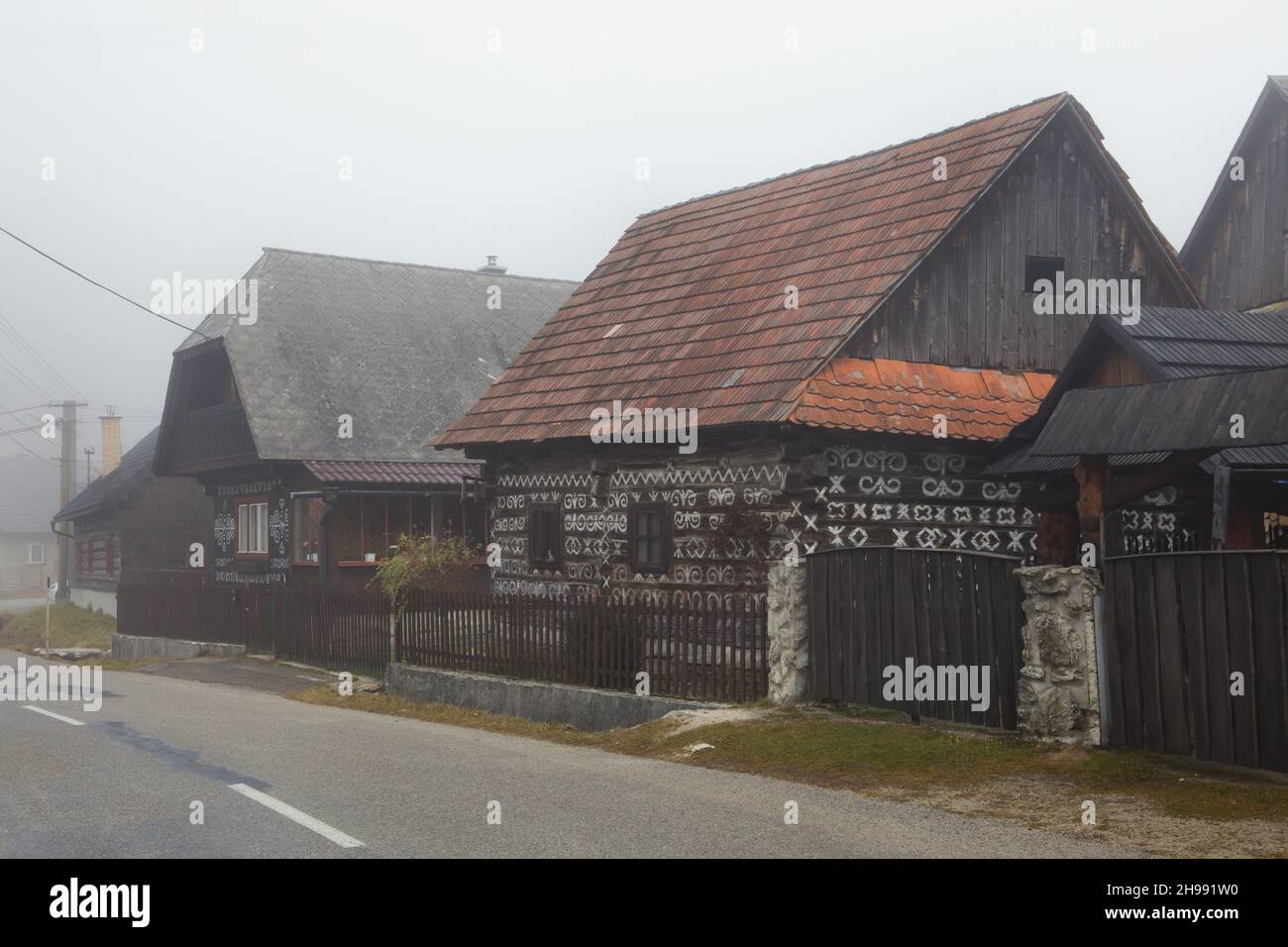 Maisons traditionnelles en rondins décorées de motifs linéaires blancs dans le village de Čičmany dans la région de Žilina en Slovaquie. Banque D'Images