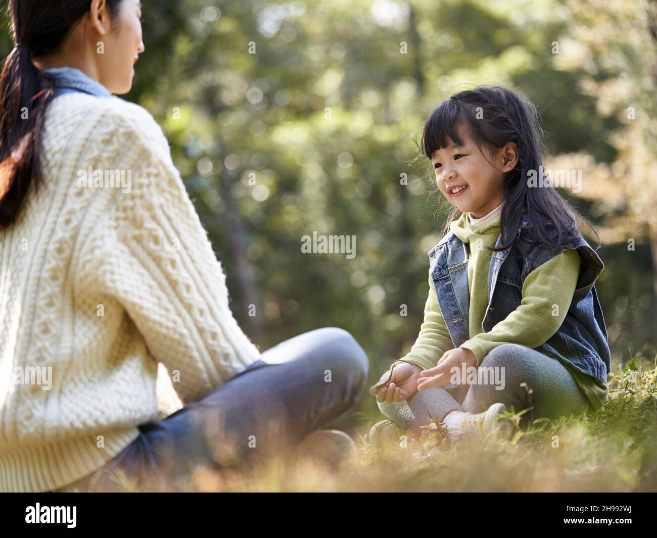 jeune fille et mère asiatique appréciant une conversation à l'extérieur dans le parc de la ville Banque D'Images