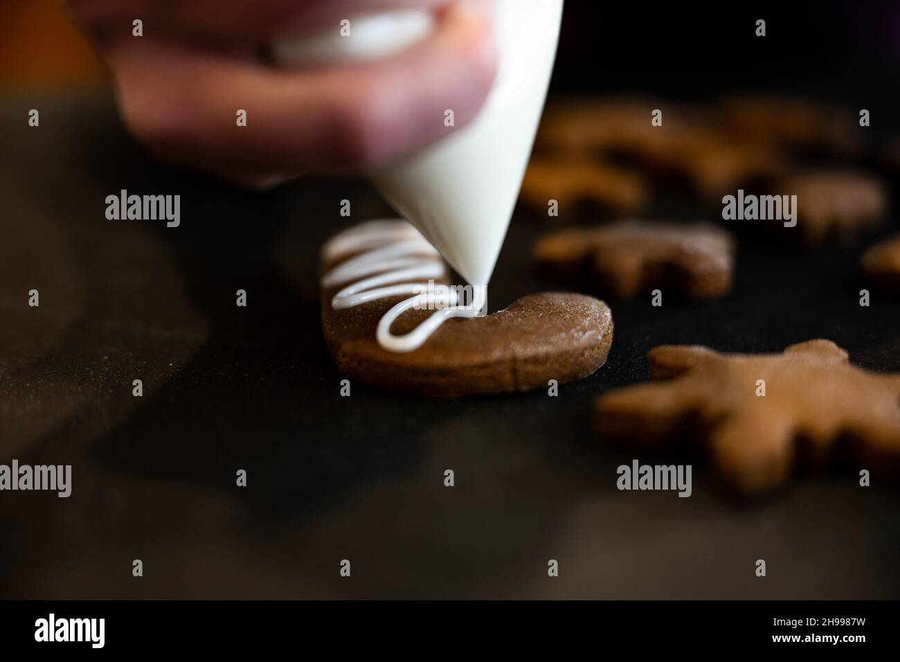 Glaçage d'un biscuit de Candy de pain d'épice avec du glaçage blanc Banque D'Images