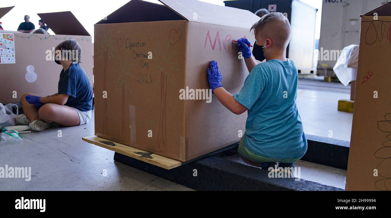 Yigo, États-Unis.04e décembre 2021.Les bénévoles emballez les produits donnés et décorent les paquets de gouttes d'air avec des messages à l'appui de la 70e chute de Noël annuelle de l'opération à la base aérienne d'Andersen le 4 décembre 2021 à Yigo, Guam.Chaque mois de décembre, des équipages feront don par avion de nourriture, de fournitures, de matériel éducatif et d’outils à 55 nations insulaires du Pacifique Sud-est.Crédit: 1lt.Jade Watkins/US Airforce photo/Alamy Live News Banque D'Images