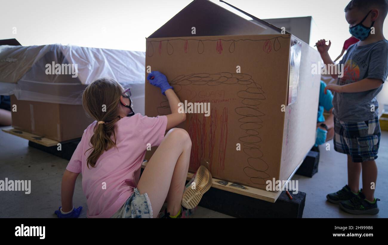 Yigo, États-Unis.04e décembre 2021.Les bénévoles emballez les produits donnés et décorent les paquets de gouttes d'air avec des messages à l'appui de la 70e chute de Noël annuelle de l'opération à la base aérienne d'Andersen le 4 décembre 2021 à Yigo, Guam.Chaque mois de décembre, des équipages feront don par avion de nourriture, de fournitures, de matériel éducatif et d’outils à 55 nations insulaires du Pacifique Sud-est.Crédit: 1lt.Jade Watkins/US Airforce photo/Alamy Live News Banque D'Images