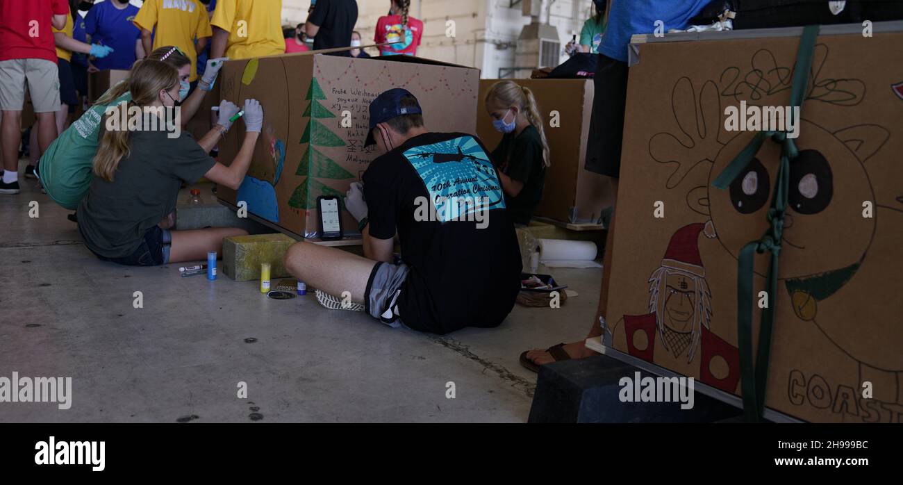 Yigo, États-Unis.04e décembre 2021.Les bénévoles emballez les produits donnés et décorent les paquets de gouttes d'air avec des messages à l'appui de la 70e chute de Noël annuelle de l'opération à la base aérienne d'Andersen le 4 décembre 2021 à Yigo, Guam.Chaque mois de décembre, des équipages feront don par avion de nourriture, de fournitures, de matériel éducatif et d’outils à 55 nations insulaires du Pacifique Sud-est.Crédit: 1lt.Jade Watkins/US Airforce photo/Alamy Live News Banque D'Images
