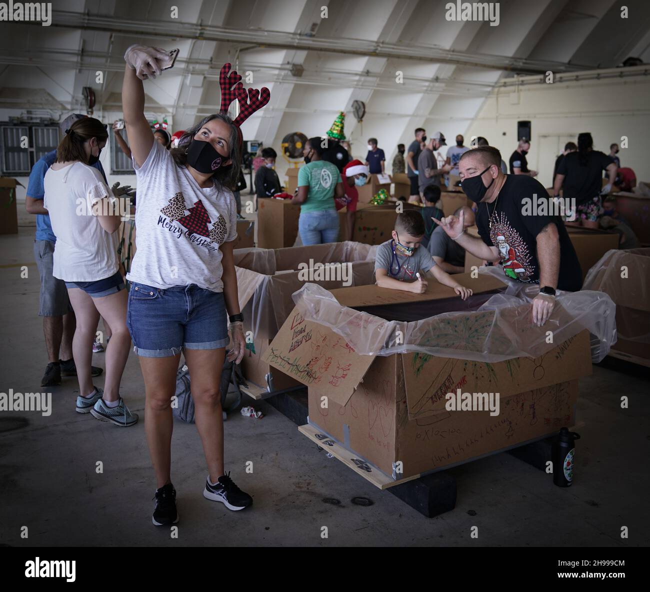 Yigo, États-Unis.04e décembre 2021.Les bénévoles emballez les produits donnés et décorent les paquets de gouttes d'air avec des messages à l'appui de la 70e chute de Noël annuelle de l'opération à la base aérienne d'Andersen le 4 décembre 2021 à Yigo, Guam.Chaque mois de décembre, des équipages feront don par avion de nourriture, de fournitures, de matériel éducatif et d’outils à 55 nations insulaires du Pacifique Sud-est.Crédit: 1lt.Jade Watkins/US Airforce photo/Alamy Live News Banque D'Images