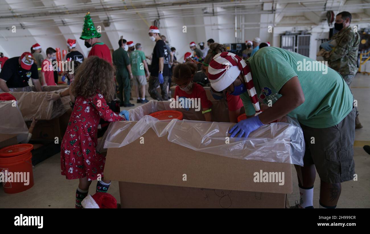 Yigo, États-Unis.04e décembre 2021.Les bénévoles emballez les produits donnés et décorent les paquets de gouttes d'air avec des messages à l'appui de la 70e chute de Noël annuelle de l'opération à la base aérienne d'Andersen le 4 décembre 2021 à Yigo, Guam.Chaque mois de décembre, des équipages feront don par avion de nourriture, de fournitures, de matériel éducatif et d’outils à 55 nations insulaires du Pacifique Sud-est.Crédit: 1lt.Jade Watkins/US Airforce photo/Alamy Live News Banque D'Images
