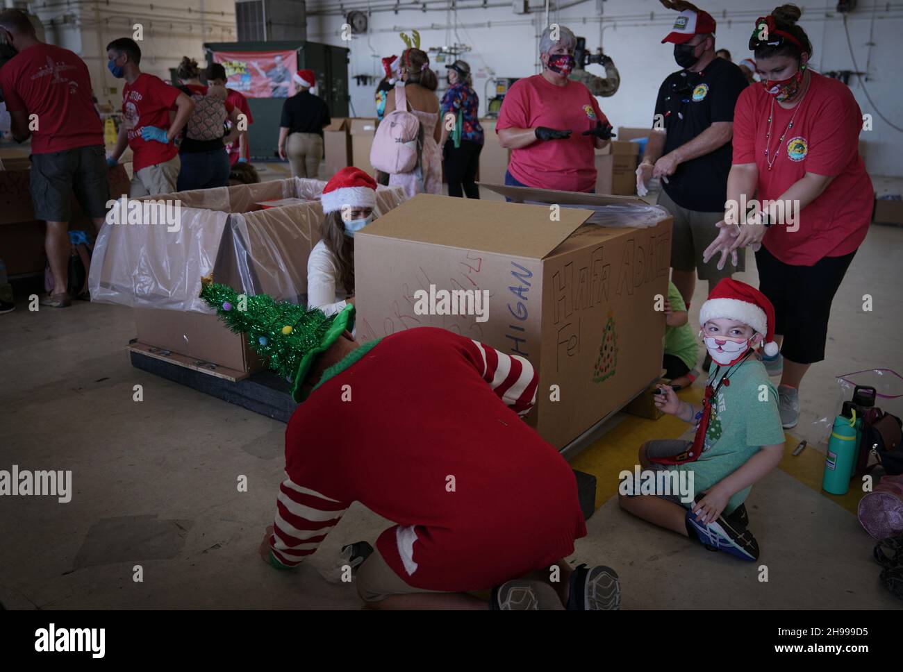 Yigo, États-Unis.04e décembre 2021.Les bénévoles emballez les produits donnés et décorent les paquets de gouttes d'air avec des messages à l'appui de la 70e chute de Noël annuelle de l'opération à la base aérienne d'Andersen le 4 décembre 2021 à Yigo, Guam.Chaque mois de décembre, des équipages feront don par avion de nourriture, de fournitures, de matériel éducatif et d’outils à 55 nations insulaires du Pacifique Sud-est.Crédit: 1lt.Jade Watkins/US Airforce photo/Alamy Live News Banque D'Images