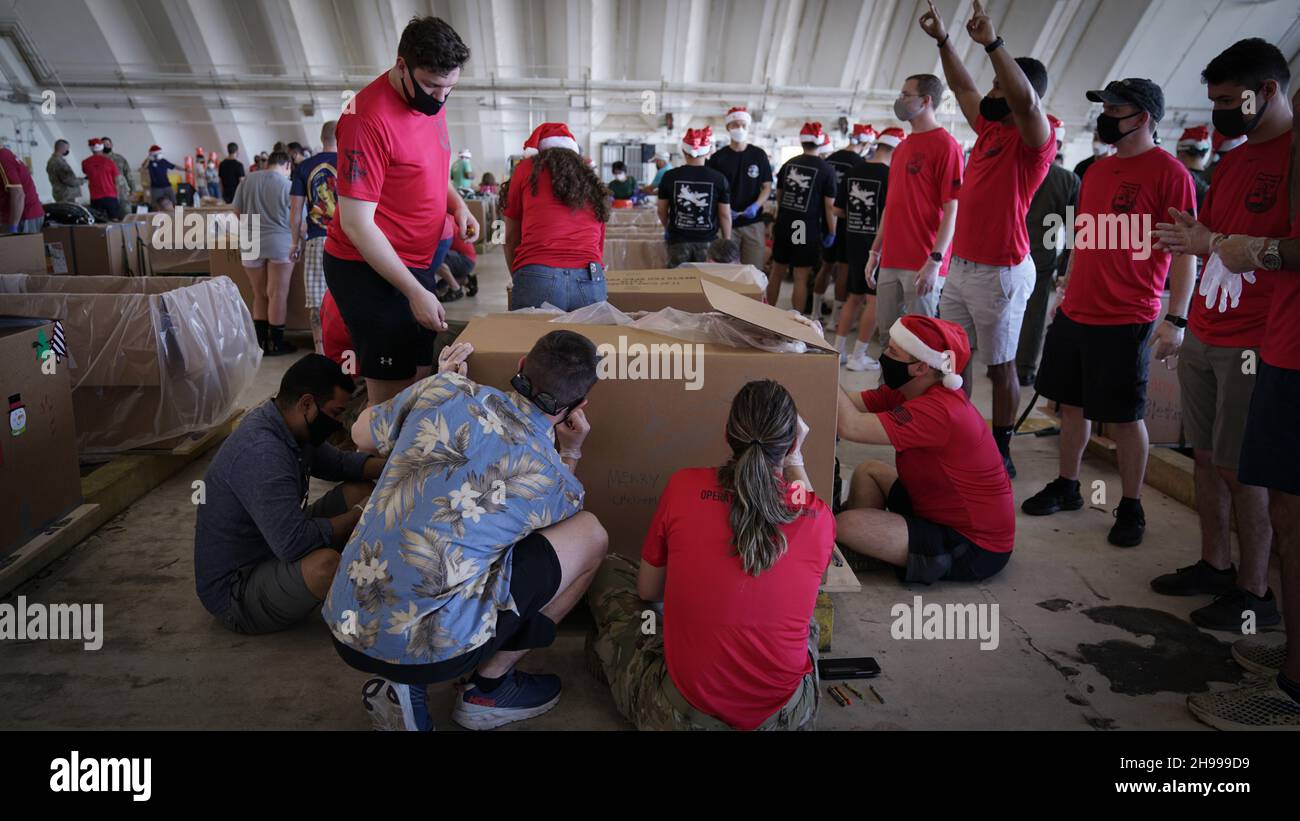 Yigo, États-Unis.04e décembre 2021.Les bénévoles emballez les produits donnés et décorent les paquets de gouttes d'air avec des messages à l'appui de la 70e chute de Noël annuelle de l'opération à la base aérienne d'Andersen le 4 décembre 2021 à Yigo, Guam.Chaque mois de décembre, des équipages feront don par avion de nourriture, de fournitures, de matériel éducatif et d’outils à 55 nations insulaires du Pacifique Sud-est.Crédit: 1lt.Jade Watkins/US Airforce photo/Alamy Live News Banque D'Images