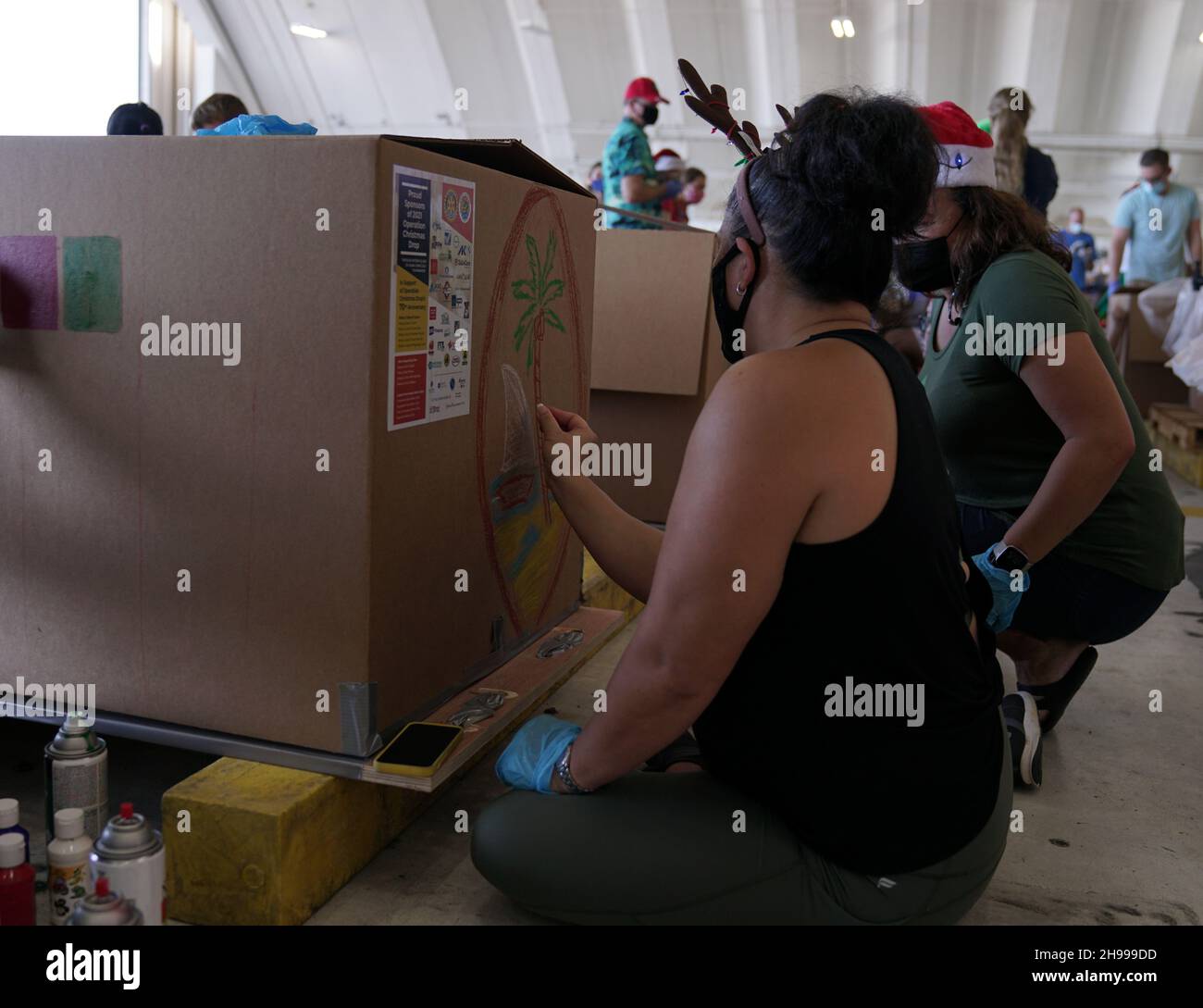 Yigo, États-Unis.04e décembre 2021.Les bénévoles emballez les produits donnés et décorent les paquets de gouttes d'air avec des messages à l'appui de la 70e chute de Noël annuelle de l'opération à la base aérienne d'Andersen le 4 décembre 2021 à Yigo, Guam.Chaque mois de décembre, des équipages feront don par avion de nourriture, de fournitures, de matériel éducatif et d’outils à 55 nations insulaires du Pacifique Sud-est.Crédit: 1lt.Jade Watkins/US Airforce photo/Alamy Live News Banque D'Images