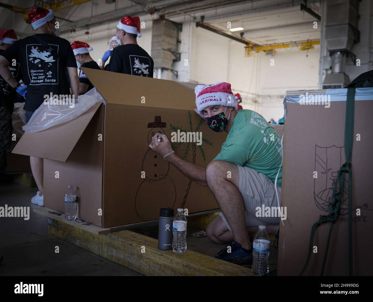 Yigo, États-Unis.04e décembre 2021.Les bénévoles emballez les produits donnés et décorent les paquets de gouttes d'air avec des messages à l'appui de la 70e chute de Noël annuelle de l'opération à la base aérienne d'Andersen le 4 décembre 2021 à Yigo, Guam.Chaque mois de décembre, des équipages feront don par avion de nourriture, de fournitures, de matériel éducatif et d’outils à 55 nations insulaires du Pacifique Sud-est.Crédit: 1lt.Jade Watkins/US Airforce photo/Alamy Live News Banque D'Images