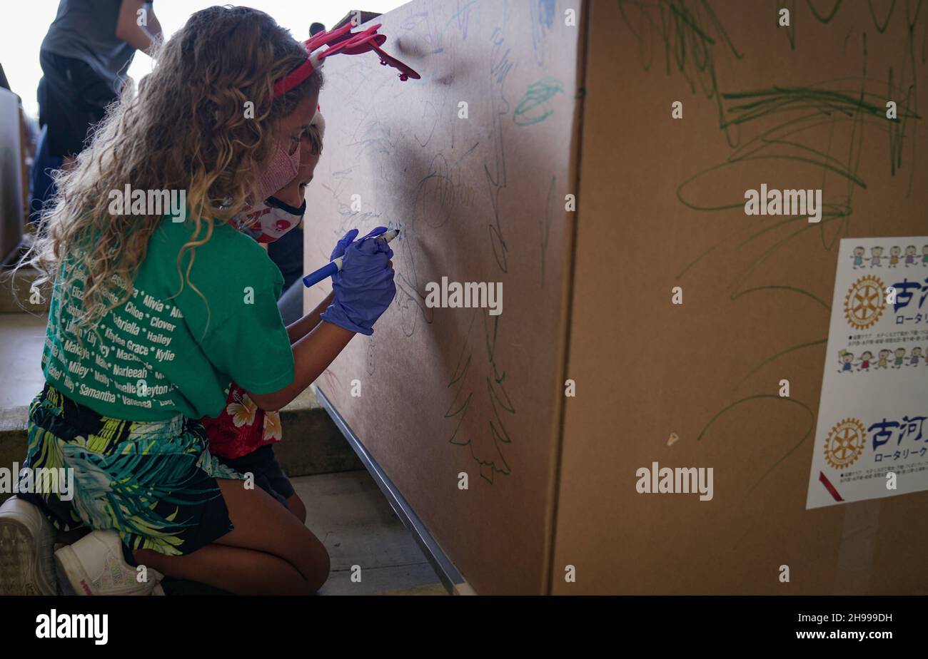 Yigo, États-Unis.04e décembre 2021.Les bénévoles emballez les produits donnés et décorent les paquets de gouttes d'air avec des messages à l'appui de la 70e chute de Noël annuelle de l'opération à la base aérienne d'Andersen le 4 décembre 2021 à Yigo, Guam.Chaque mois de décembre, des équipages feront don par avion de nourriture, de fournitures, de matériel éducatif et d’outils à 55 nations insulaires du Pacifique Sud-est.Crédit: 1lt.Jade Watkins/US Airforce photo/Alamy Live News Banque D'Images