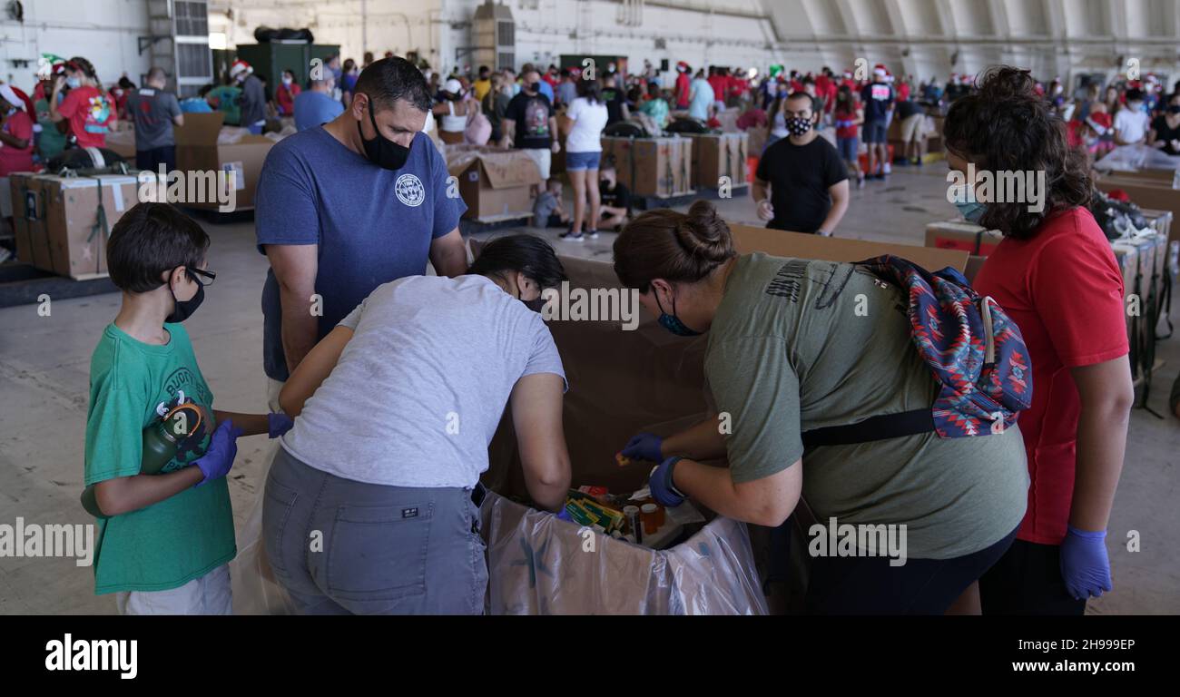 Yigo, États-Unis.04e décembre 2021.Les bénévoles emballez les produits donnés et décorent les paquets de gouttes d'air avec des messages à l'appui de la 70e chute de Noël annuelle de l'opération à la base aérienne d'Andersen le 4 décembre 2021 à Yigo, Guam.Chaque mois de décembre, des équipages feront don par avion de nourriture, de fournitures, de matériel éducatif et d’outils à 55 nations insulaires du Pacifique Sud-est.Crédit: 1lt.Jade Watkins/US Airforce photo/Alamy Live News Banque D'Images