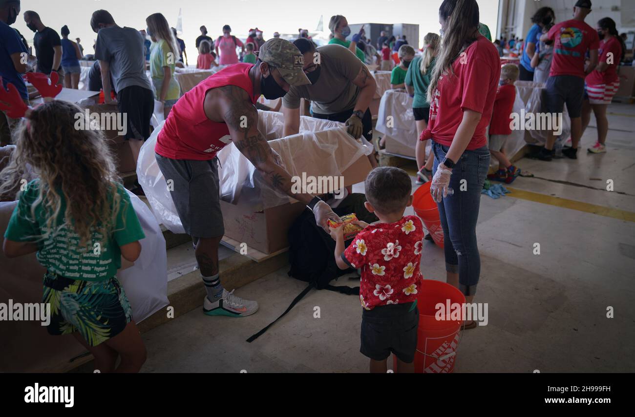 Yigo, États-Unis.04e décembre 2021.Les bénévoles emballez les produits donnés et décorent les paquets de gouttes d'air avec des messages à l'appui de la 70e chute de Noël annuelle de l'opération à la base aérienne d'Andersen le 4 décembre 2021 à Yigo, Guam.Chaque mois de décembre, des équipages feront don par avion de nourriture, de fournitures, de matériel éducatif et d’outils à 55 nations insulaires du Pacifique Sud-est.Crédit: 1lt.Jade Watkins/US Airforce photo/Alamy Live News Banque D'Images