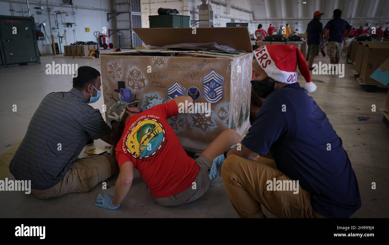 Yigo, États-Unis.04e décembre 2021.Les bénévoles emballez les produits donnés et décorent les paquets de gouttes d'air avec des encouragements de Noël lors des préparatifs de la 70e chute de Noël annuelle de l'opération à la base aérienne d'Andersen le 4 décembre 2021 à Yigo, Guam.Chaque mois de décembre, des équipages feront don par avion de nourriture, de fournitures, de matériel éducatif et d’outils à 55 nations insulaires du Pacifique Sud-est.Crédit : MSGT.Richard Ebensberger/US Airforce photo/Alamy Live News Banque D'Images