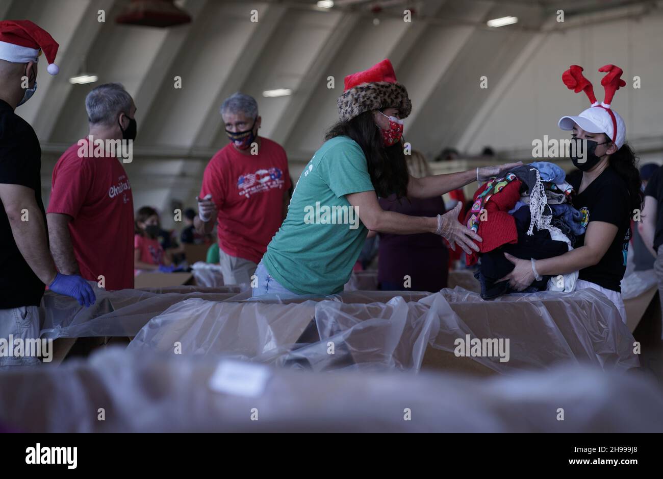Yigo, États-Unis.04e décembre 2021.Les volontaires emballez les produits donnés dans des paquets de gouttes d'air lors des préparatifs de la 70e chute de Noël annuelle de l'opération à la base aérienne d'Andersen le 4 décembre 2021 à Yigo, Guam.Chaque mois de décembre, des équipages feront don par avion de nourriture, de fournitures, de matériel éducatif et d’outils à 55 nations insulaires du Pacifique Sud-est.Crédit : MSGT.Richard Ebensberger/US Airforce photo/Alamy Live News Banque D'Images
