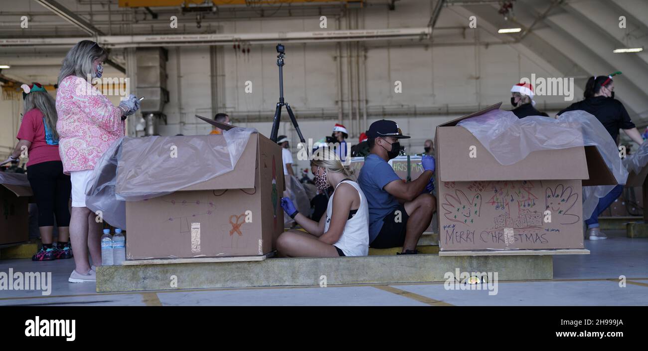 Yigo, États-Unis.04e décembre 2021.Les bénévoles emballez les produits donnés et décorent les paquets de gouttes d'air avec des encouragements de Noël lors des préparatifs de la 70e chute de Noël annuelle de l'opération à la base aérienne d'Andersen le 4 décembre 2021 à Yigo, Guam.Chaque mois de décembre, des équipages feront don par avion de nourriture, de fournitures, de matériel éducatif et d’outils à 55 nations insulaires du Pacifique Sud-est.Crédit : MSGT.Richard Ebensberger/US Airforce photo/Alamy Live News Banque D'Images