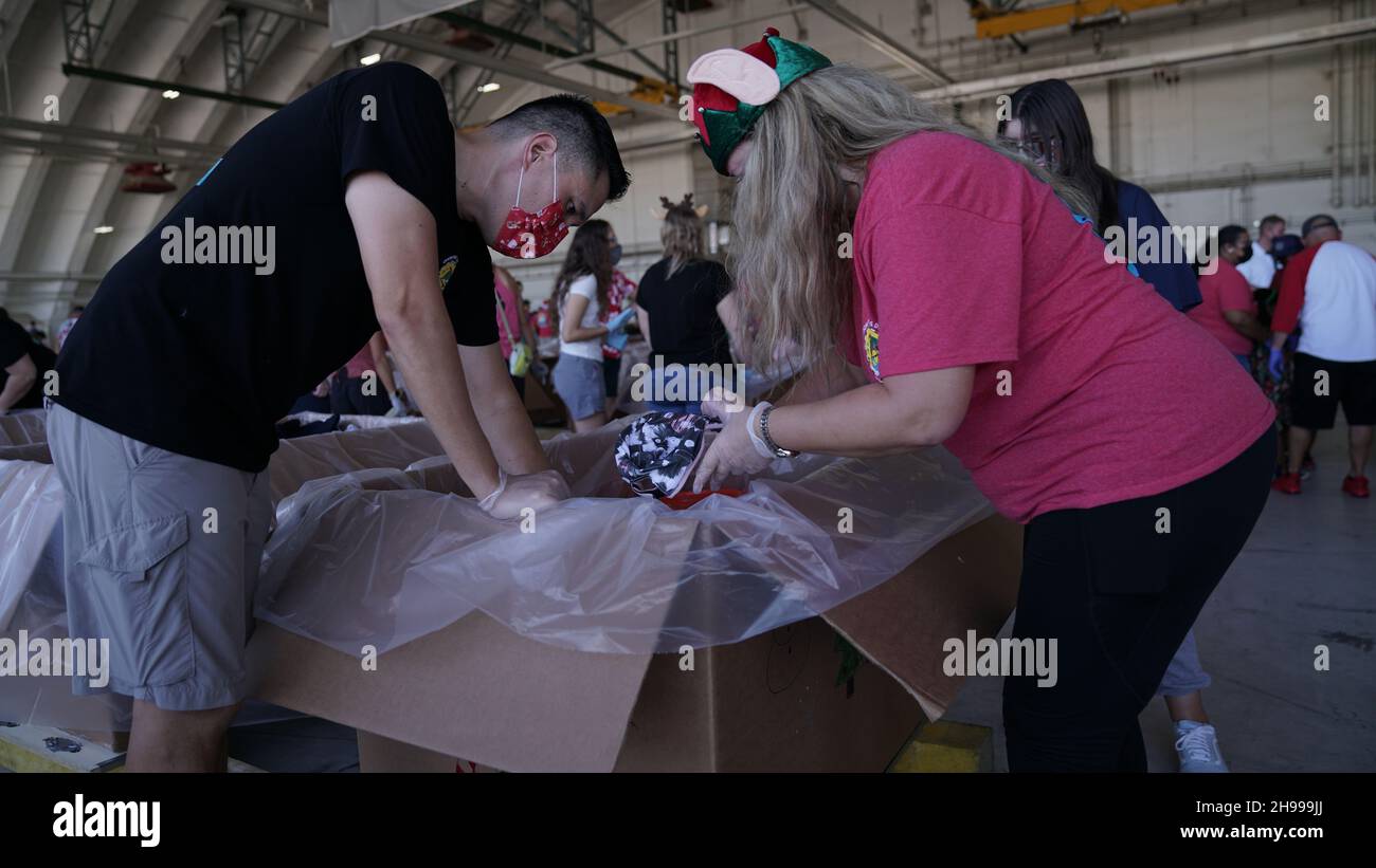 Yigo, États-Unis.04e décembre 2021.Les volontaires emballez les produits donnés dans des paquets de gouttes d'air lors des préparatifs de la 70e chute de Noël annuelle de l'opération à la base aérienne d'Andersen le 4 décembre 2021 à Yigo, Guam.Chaque mois de décembre, des équipages feront don par avion de nourriture, de fournitures, de matériel éducatif et d’outils à 55 nations insulaires du Pacifique Sud-est.Crédit : MSGT.Richard Ebensberger/US Airforce photo/Alamy Live News Banque D'Images