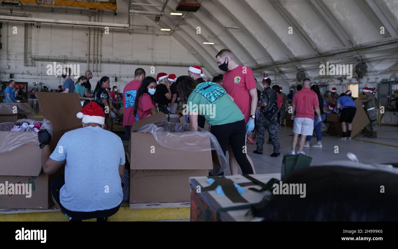 Yigo, États-Unis.04e décembre 2021.Les volontaires emballez les produits donnés dans des paquets de gouttes d'air lors des préparatifs de la 70e chute de Noël annuelle de l'opération à la base aérienne d'Andersen le 4 décembre 2021 à Yigo, Guam.Chaque mois de décembre, des équipages feront don par avion de nourriture, de fournitures, de matériel éducatif et d’outils à 55 nations insulaires du Pacifique Sud-est.Crédit : MSGT.Richard Ebensberger/US Airforce photo/Alamy Live News Banque D'Images