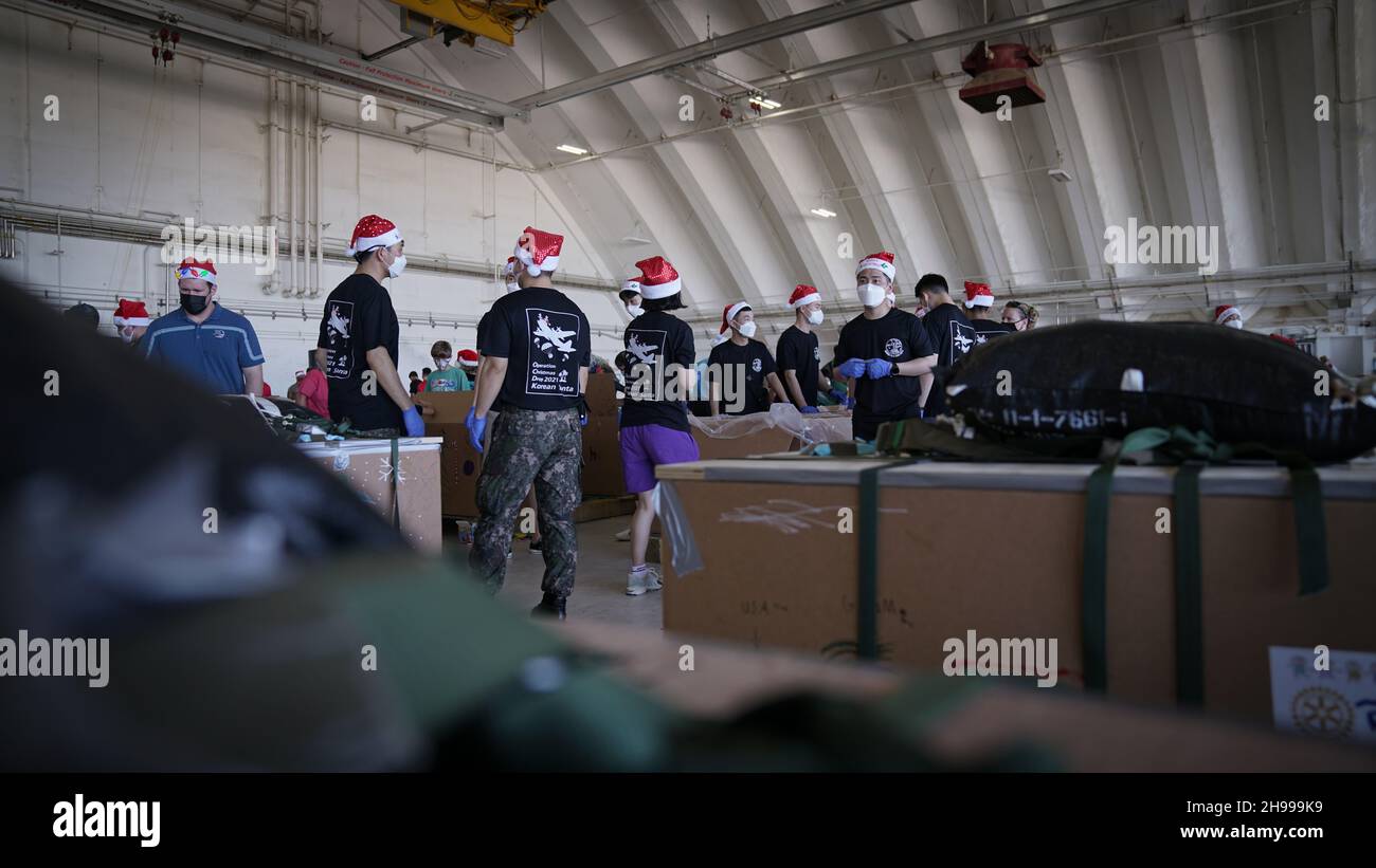 Yigo, États-Unis.04e décembre 2021.Les volontaires emballez les produits donnés dans des paquets de gouttes d'air lors des préparatifs de la 70e chute de Noël annuelle de l'opération à la base aérienne d'Andersen le 4 décembre 2021 à Yigo, Guam.Chaque mois de décembre, des équipages feront don par avion de nourriture, de fournitures, de matériel éducatif et d’outils à 55 nations insulaires du Pacifique Sud-est.Crédit : MSGT.Richard Ebensberger/US Airforce photo/Alamy Live News Banque D'Images
