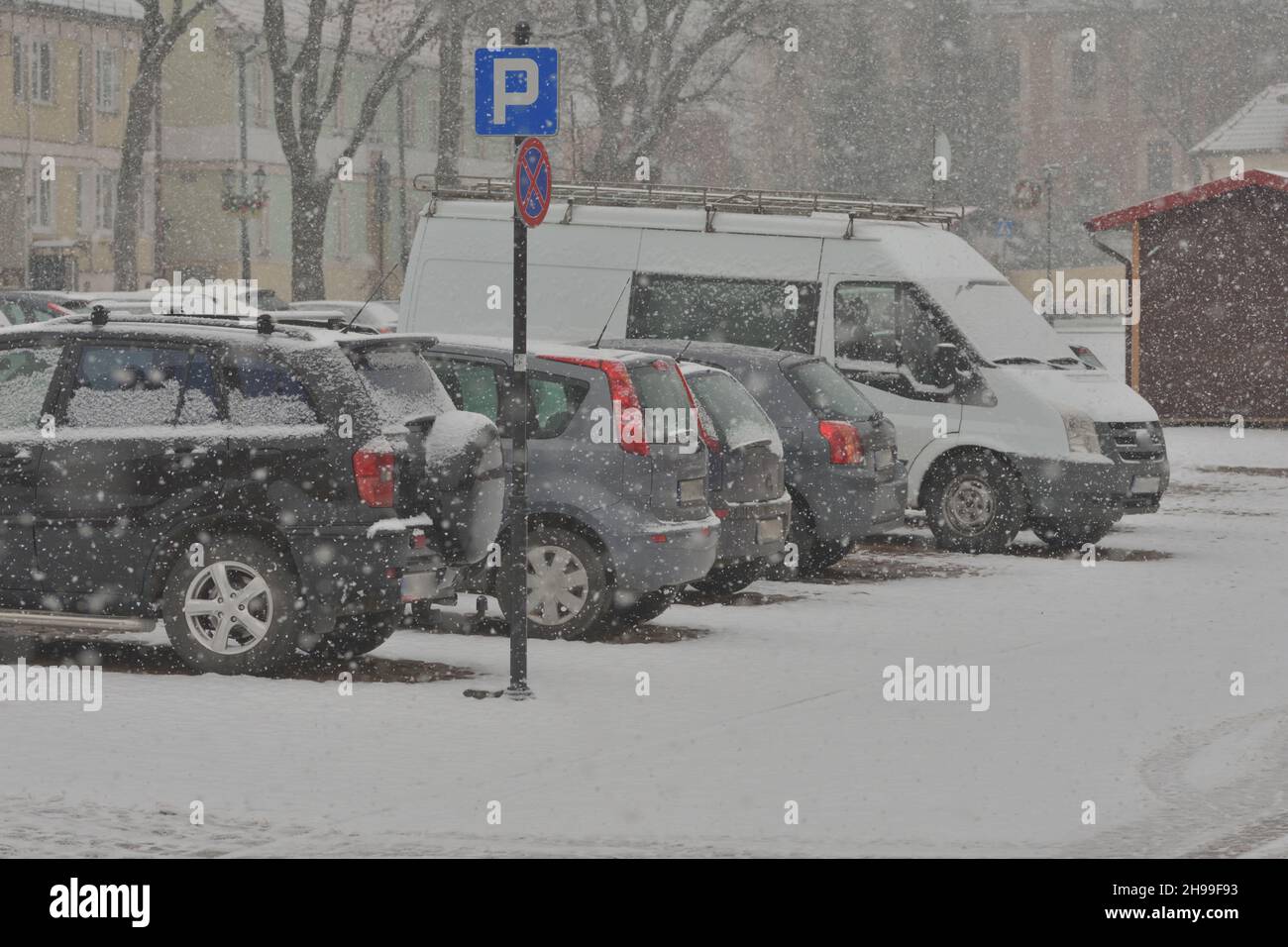 Route enneigée, traces de roue dans la neige et voitures enneigées lors de fortes chutes de neige.Jour. Banque D'Images